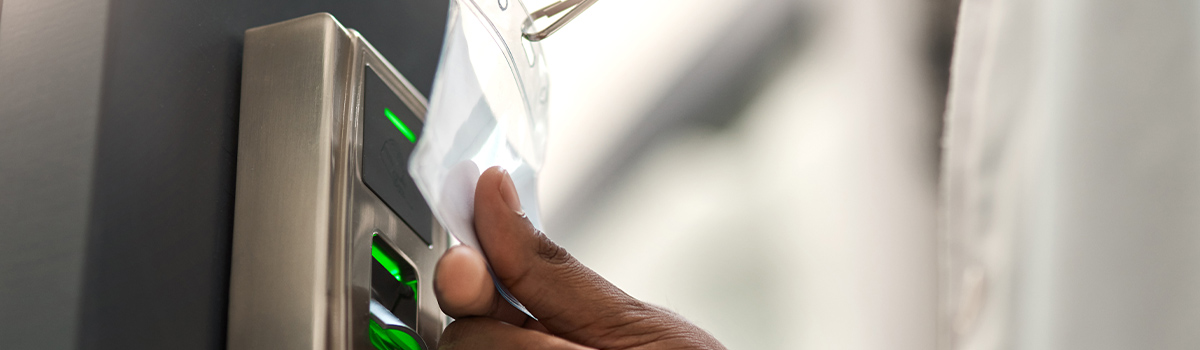 Employee using building entry badge on access control system, highlighting security measures for data centers and infrastructure.