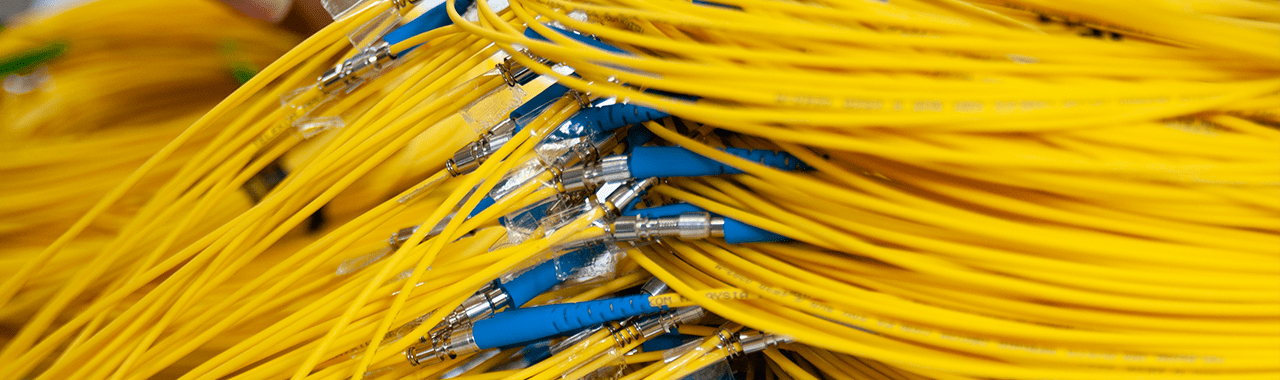 Yellow fiber optic cables with blue connectors, showcasing structured cabling solutions for network infrastructure in Las Vegas.