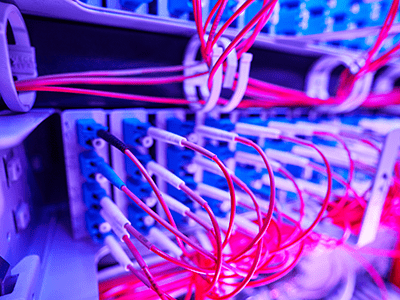 Fiber optic cables in a network rack, showcasing organized connections and vibrant colors, representing advanced data center cabling solutions by Universal Fiber Optics.