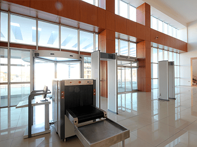 Modern security screening area with metal detectors and baggage scanner, designed for government facilities and advanced network cabling installations.