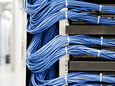 Organized blue network cables in a structured server rack, illustrating efficient cable management for IT infrastructure.