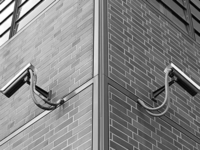 Security cameras mounted on a brick building corner, emphasizing surveillance and safety in network infrastructure for data centers.