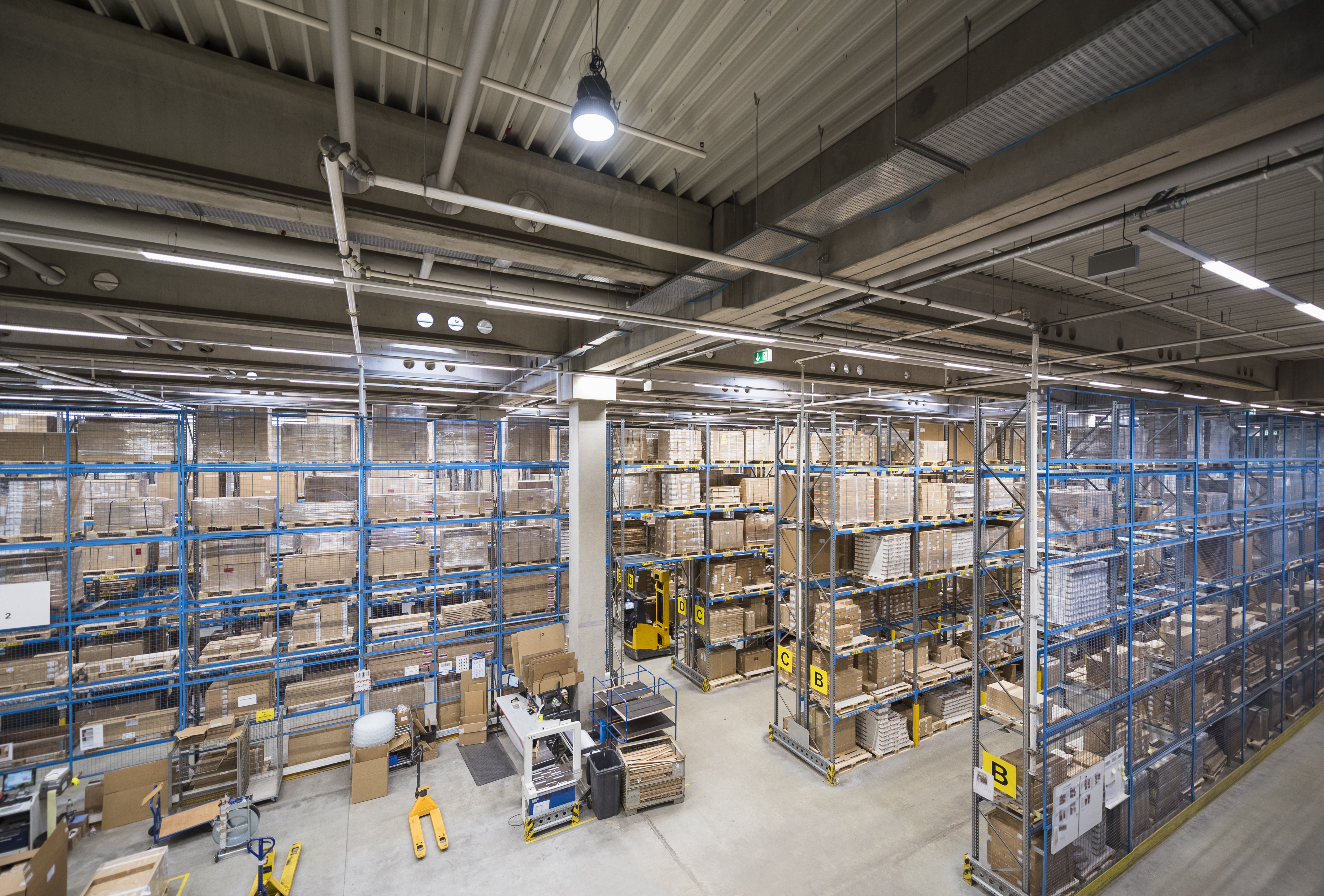 Warehouse interior showcasing organized shelving units filled with boxes, highlighting a structured environment suitable for advanced network cabling installations.