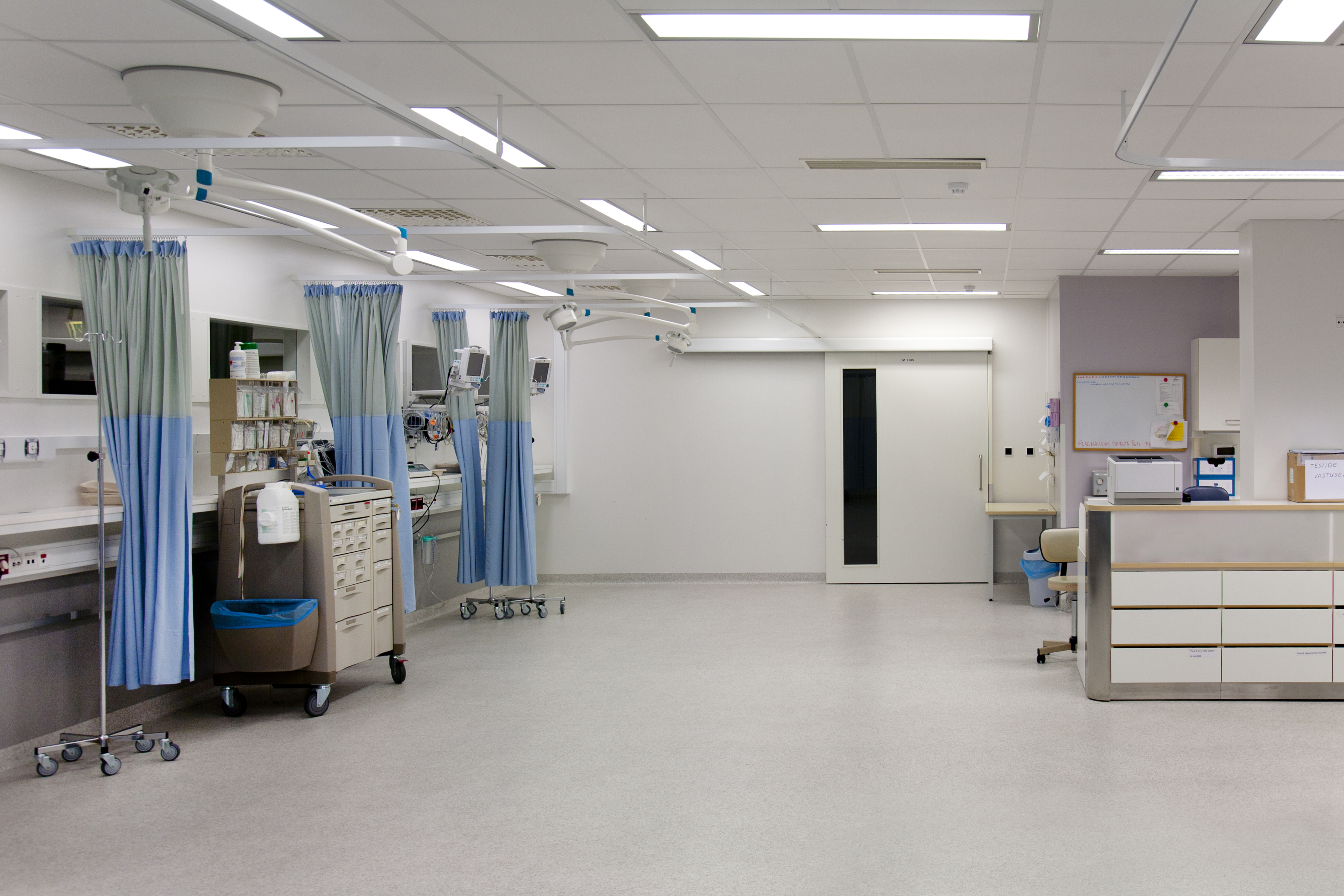 Modern hospital room with medical equipment, curtains, and a clean, organized environment for patient care, emphasizing advanced network cabling services for hospitals.